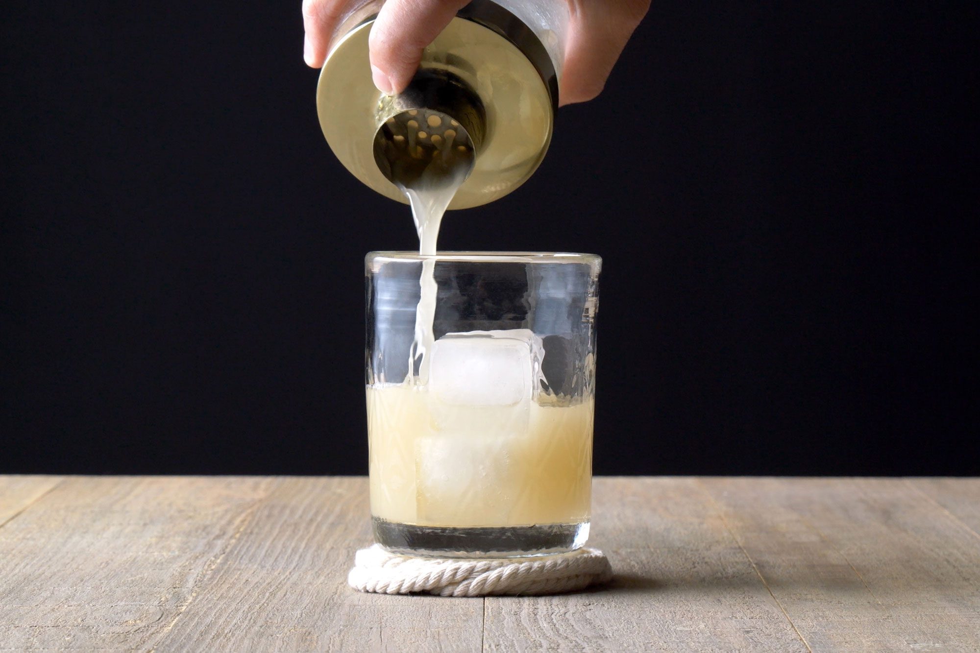 Straining into double rocks glass filled with ice