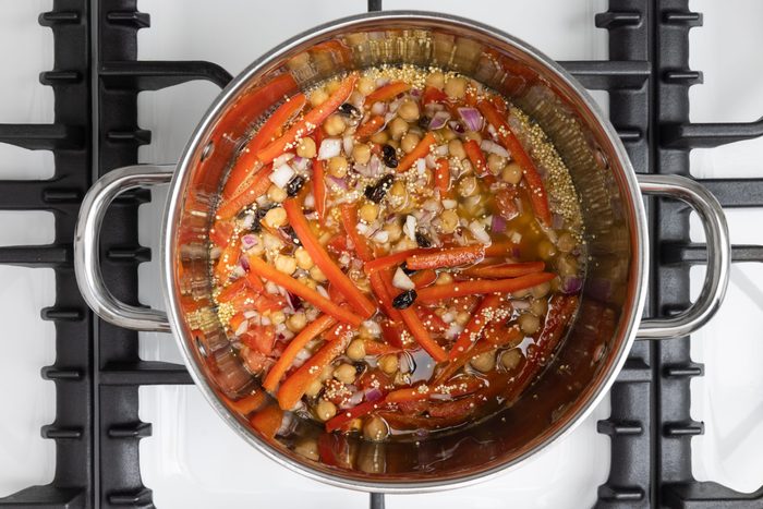 Ingredients being mixed in the orange juice and water solution to boil and simmer on pot.