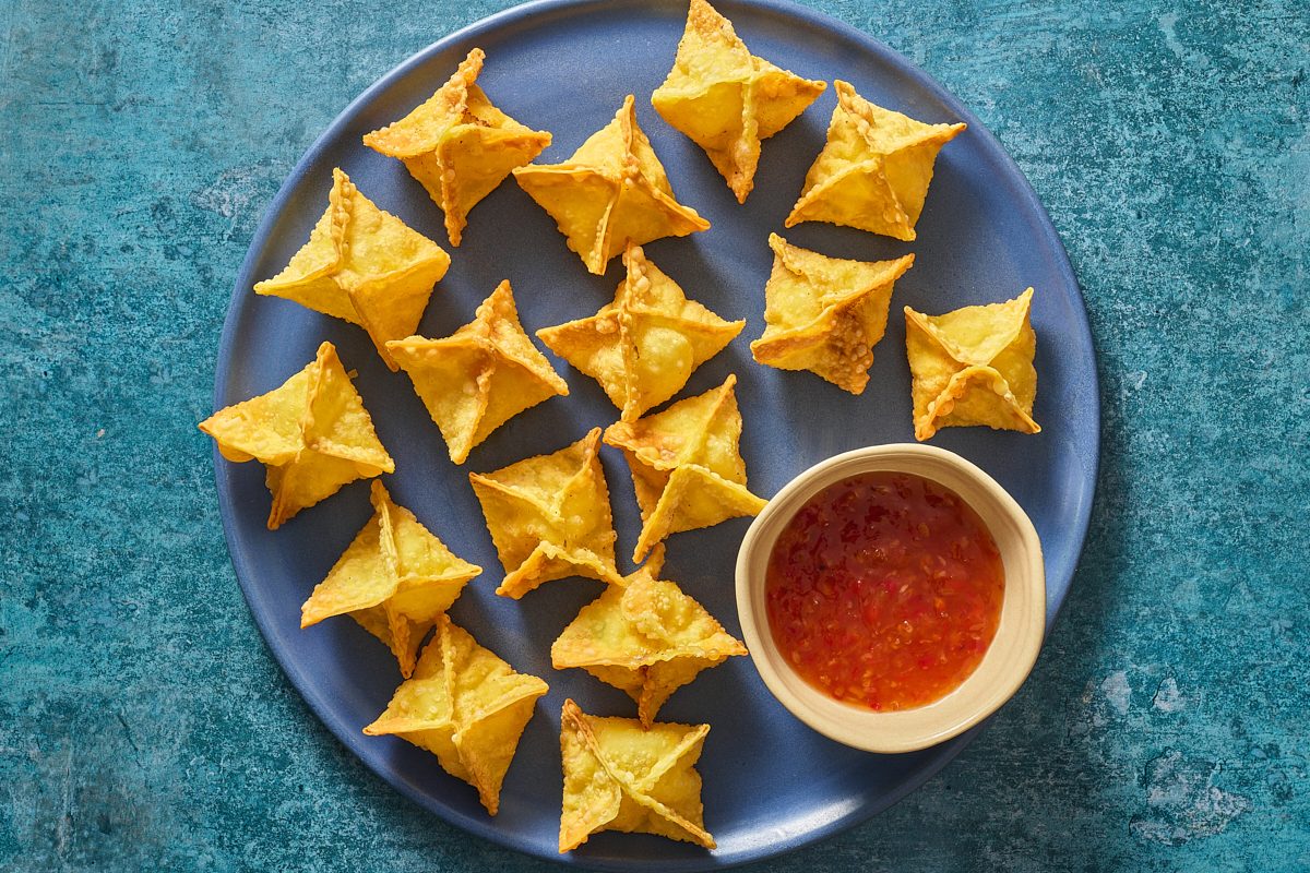 Overhead shot of shrimp rangoon on a plate with some dipping sauce