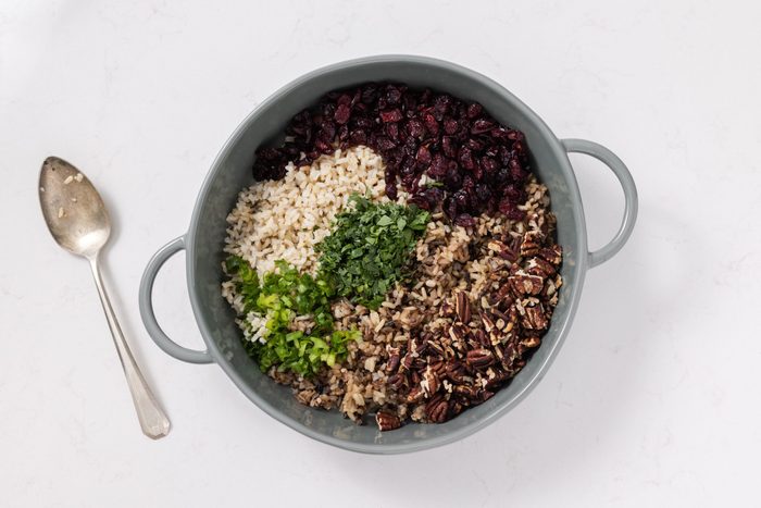 Ingredients For Wild Rice Salad Being Mixed In Serving Bowl.