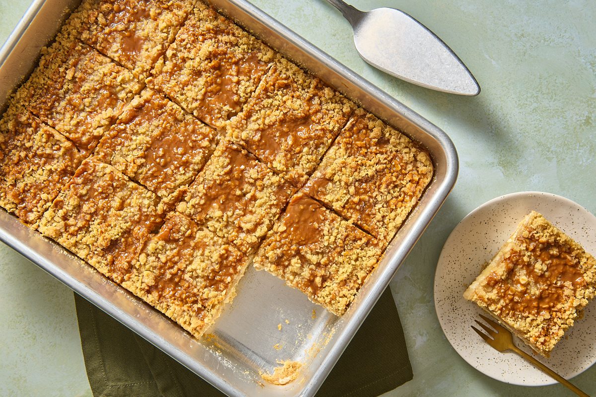 Apple Caramel Cheesecake Bars cut into squares, with one served on a plate
