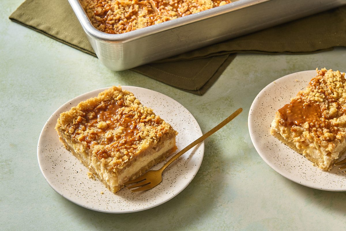 Two apple caramel cheesecake bars on plates