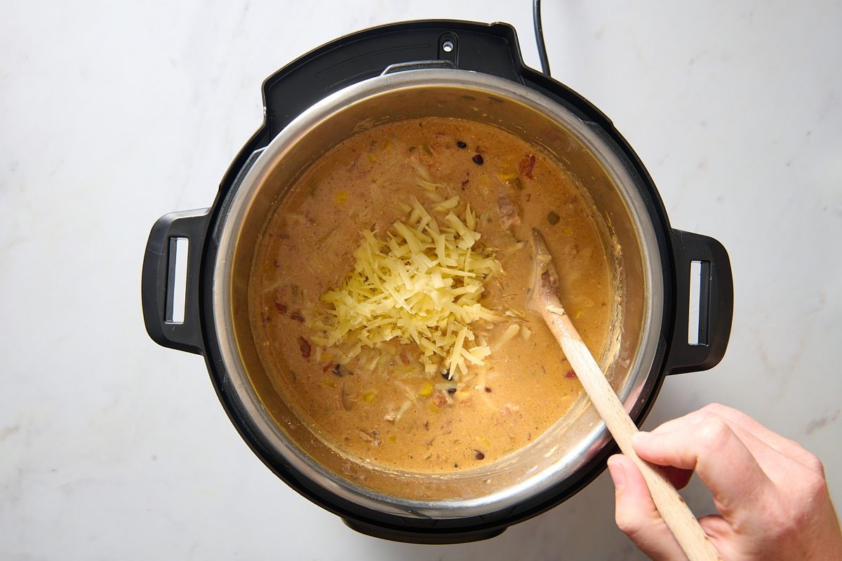 Stirring in the shredded cheese