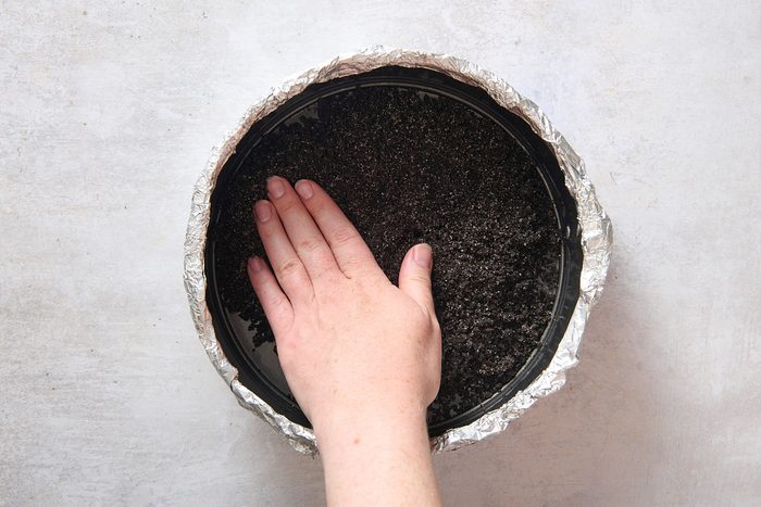 Pressing the crust into the base of the pan