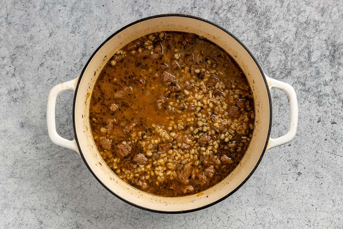 Taste of Home Beef Barley Stew recipe photo of all the ingredients, except the carrots and parsley, cooked in a dutch oven.