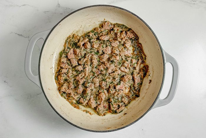 Ingredients for Taste of Home Bitterballen in a ceramic skillet set on a marble surface.