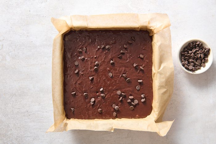 Sprinkling chocolate chips over the batter in a square baking pan