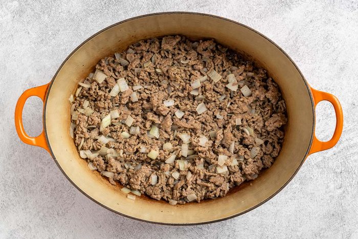 Taste of Home Black Eyed Pea Soup recipe photo of the cooked beef, sausage and onion in a Dutch oven.