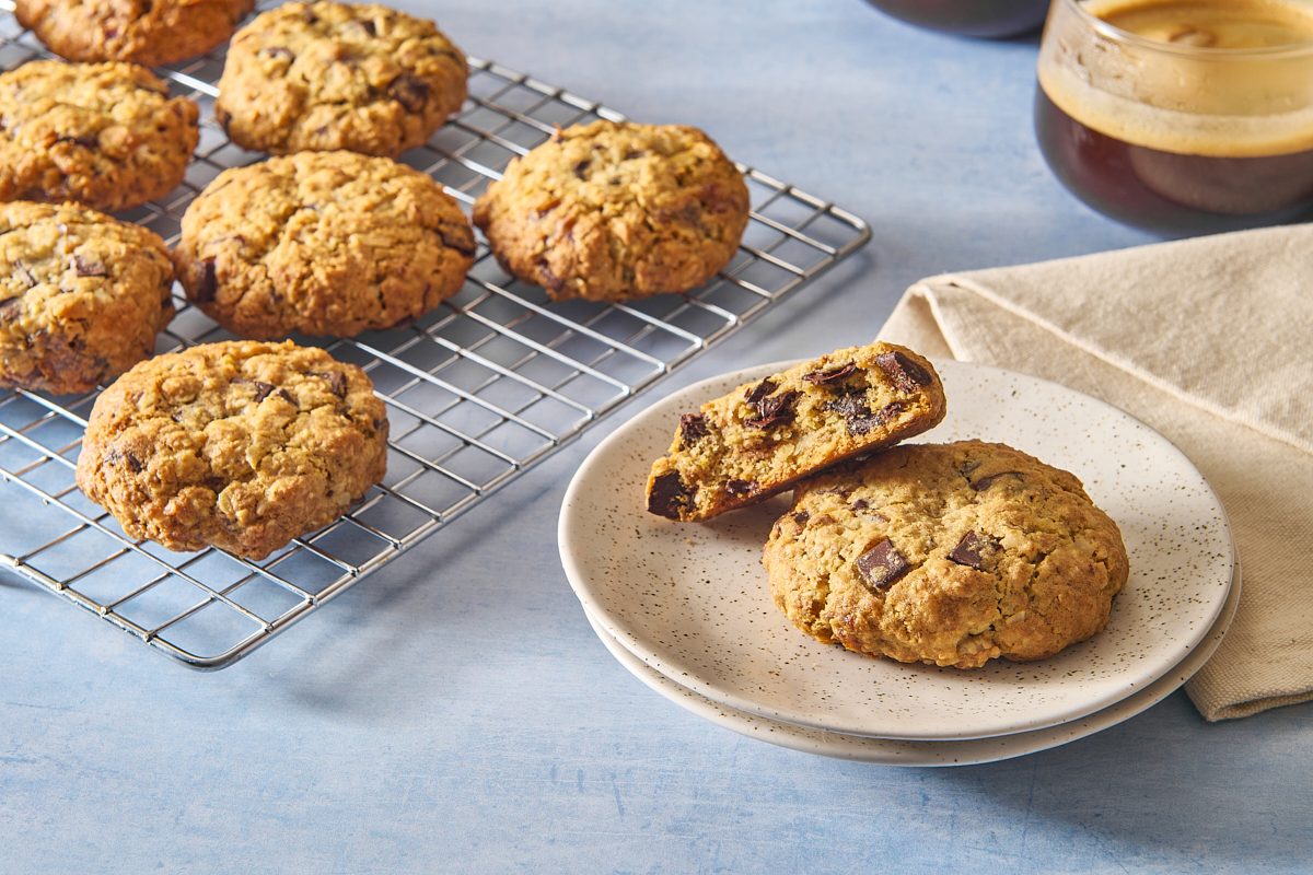 A serving of breakfast cookies on a plate, with one broken in half