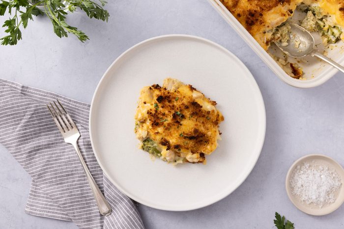 Casserole Served On Plate With Baking Dish Close By.