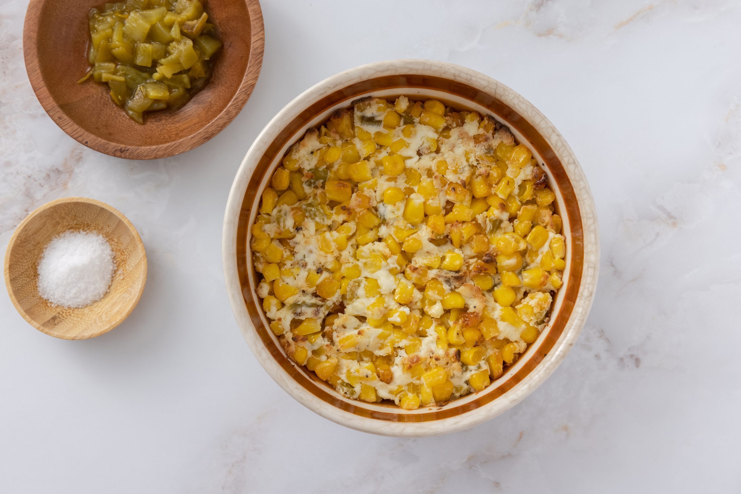 Corn casserole with cream cheese served in baking dish.