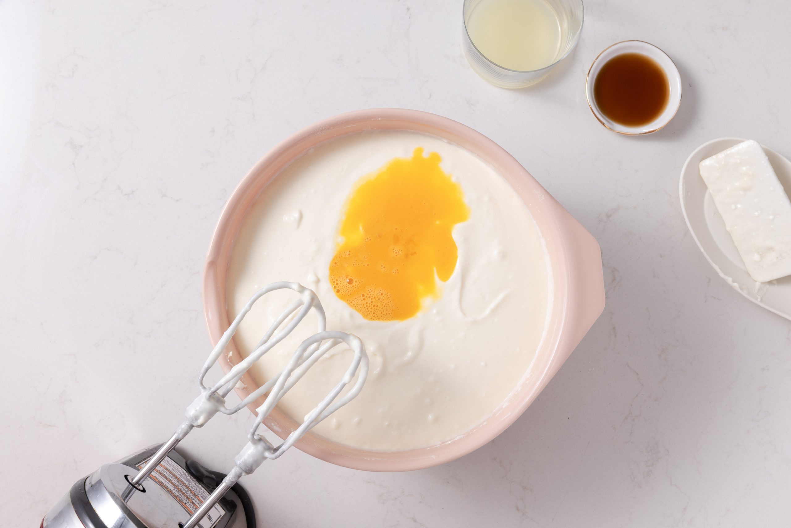 Adding eggs, vanilla extract and lemon juice to the batter.