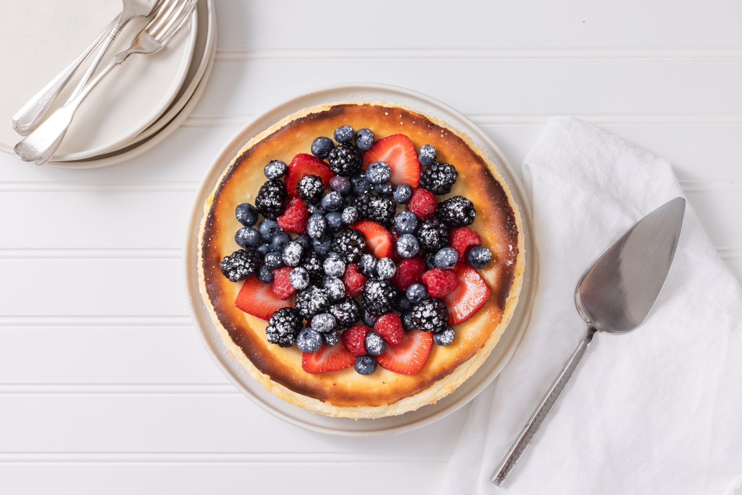 Cheesecake ready, topped with fresh berries and served on serving plate.
