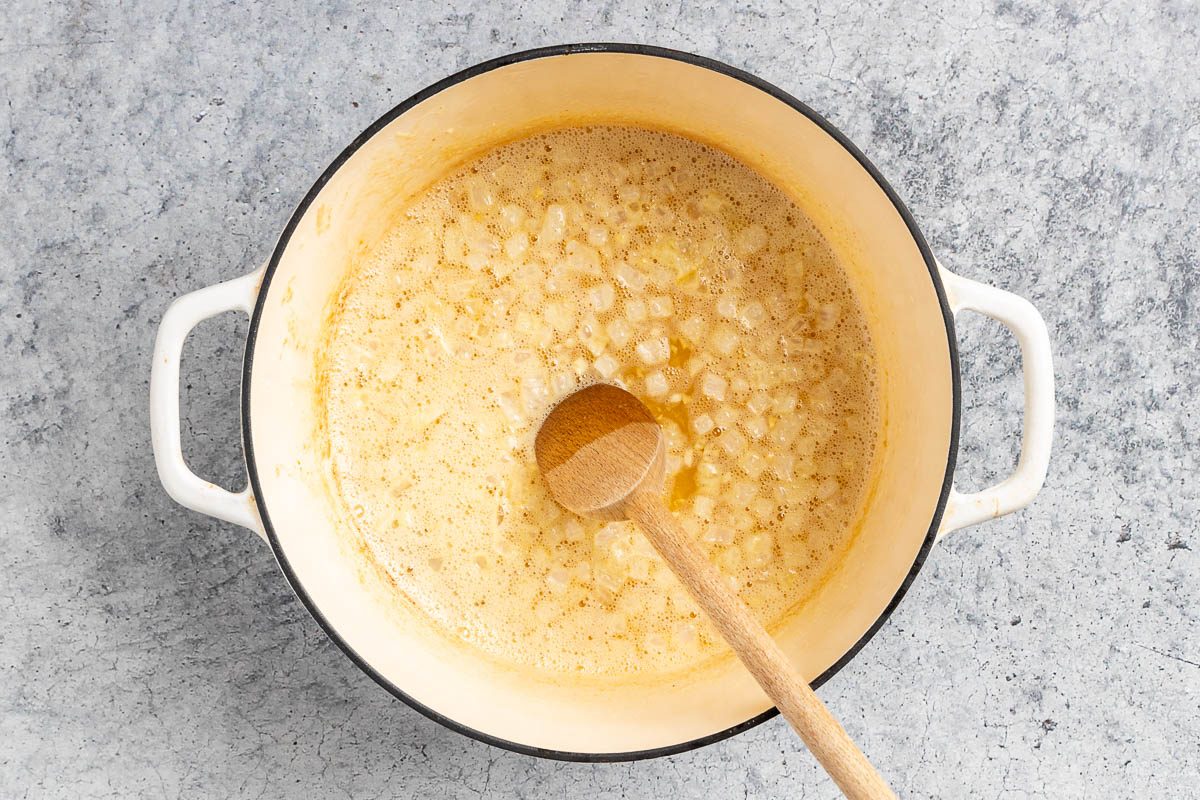Taste of Home Dill Pickle Soup recipe photo of the sauteed onion and garlic in a Dutch oven.