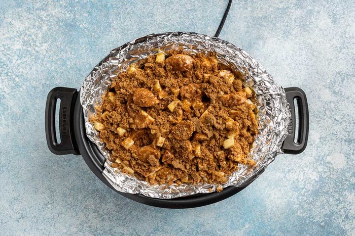 Taste of Home Donut Bread Pudding recipe photo the cream, eggs and vanilla mixture mixed with the cinnamon and brown sugar, then sprinkled on top of the donuts and apples.