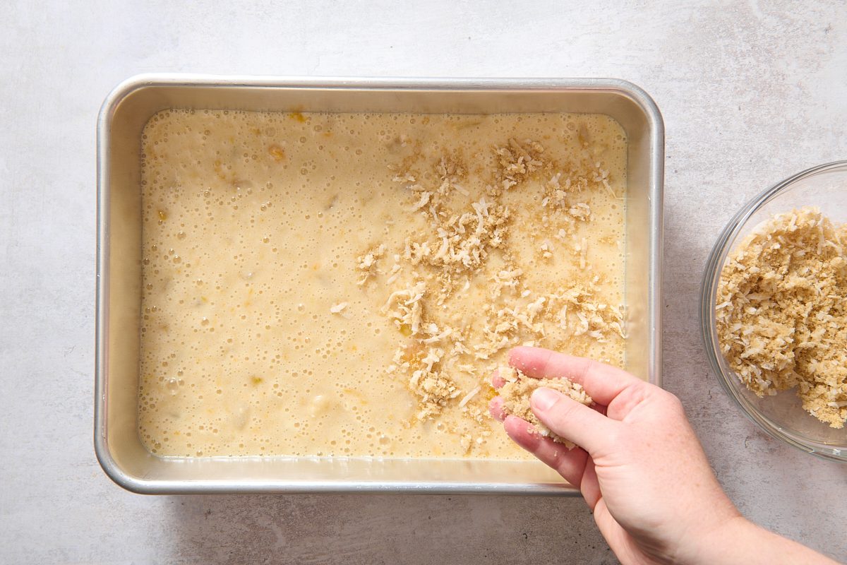 Sprinkling topping over the batter in a baking dish
