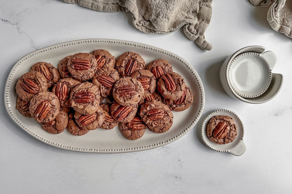 Taste of Home German chocolate cookies on white ceramic plates with a linen napkin on a marble surface.