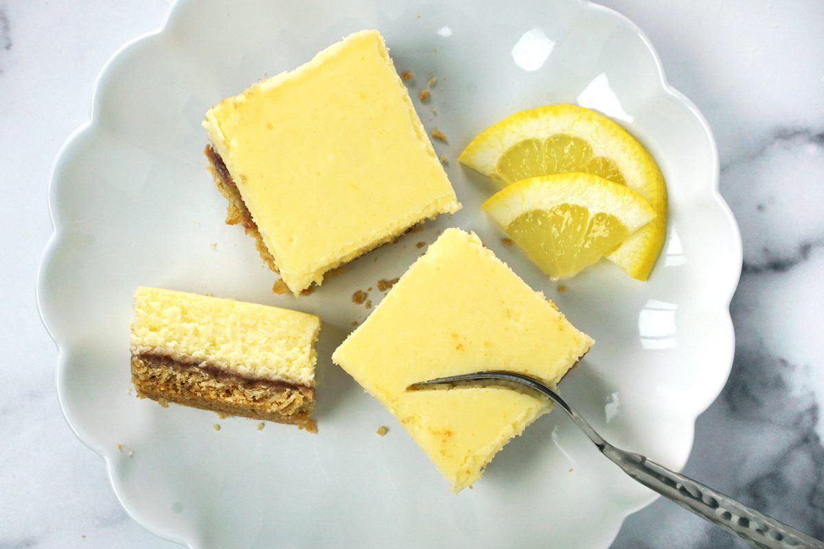 A plate of Taste of Home lemon cheesecake bars with a fork cutting one RMS 15811