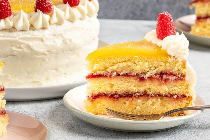 Taste of Home Lemon Raspberry Cake recipe photo of the cake cut into slices and served on plates.