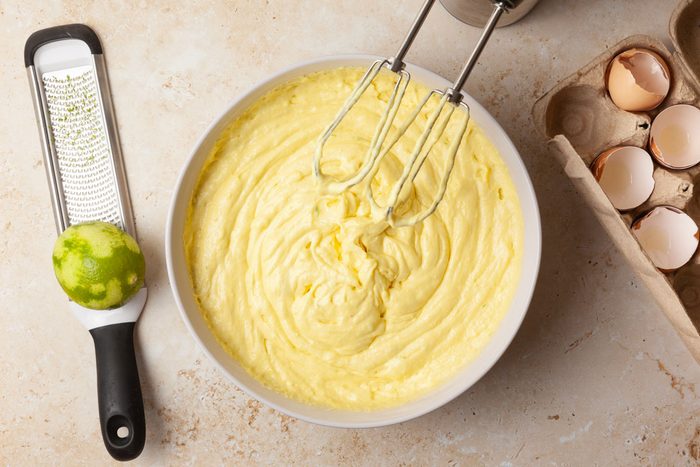 Step 1 of Taste of Home Margarita Cake is to combine cake mix, pudding mix, margarita mix, eggs, butter, lime juice and zest. Beat it at low speed for 30 seconds, then medium speed for two minutes.