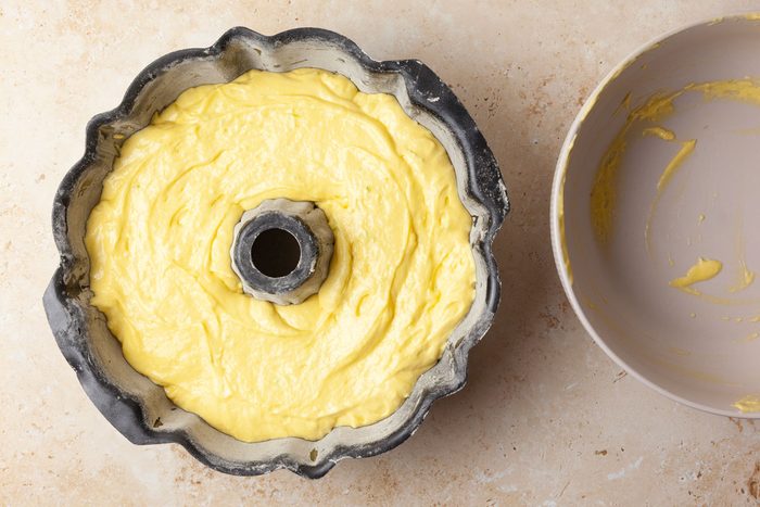 Step 2 of Taste of Home Margarita Cake is to transfer the batter to a greased and floured 10-inch fluted bundt pan. Bake it at 350°F for 45 to 50 minutes or until a toothpick inserted in the center comes out clean. Cool the cake in the pan for 10 minutes before removing it to a wire rack to cool completely.