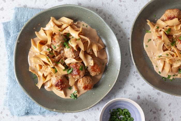 Single servings of Taste of Home Meatball Stroganoff on green plates, garnished with parsley