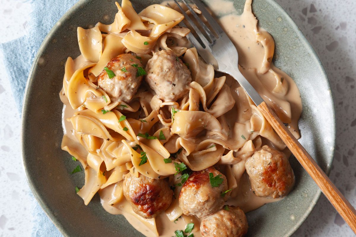 Single servings of Taste of Home Meatball Stroganoff on green plates, garnished with parsley