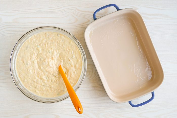 Cornbread batter ready to be poured into a blue casserole dish