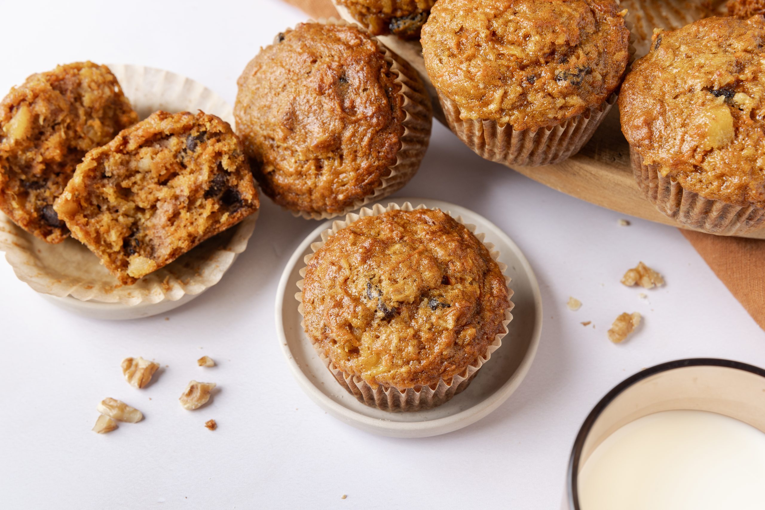 Muffins displayed on little plates and wooden board.