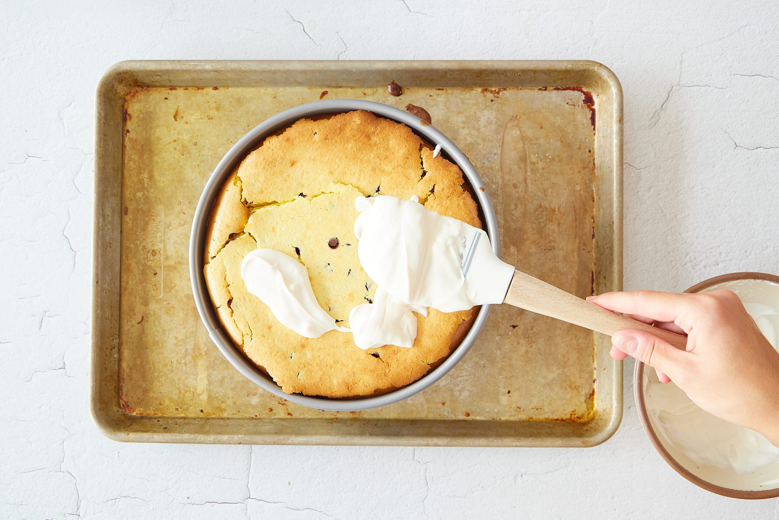 Add the sour cream layer to the chocolate chip cookie cheesecake.