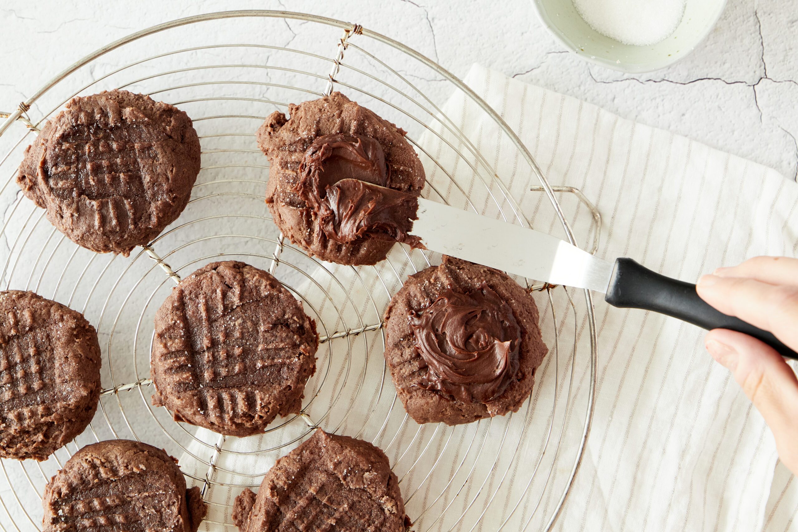 Frost the chocolate peanut butter cookies.