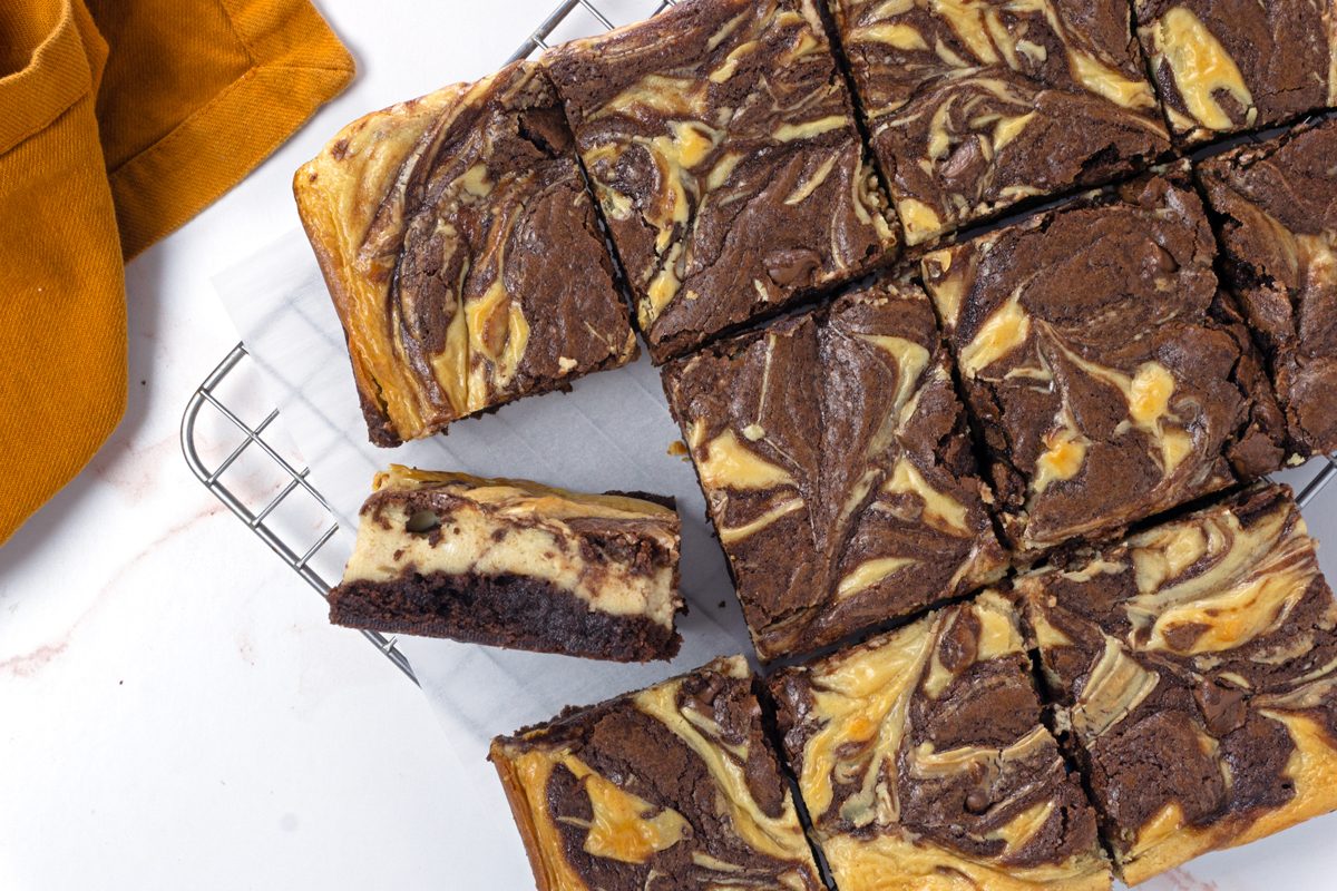 An overhead image of sliced peanut butter swirl brownies on a cooling rack with parchment paper for Taste of Home RMS 11889