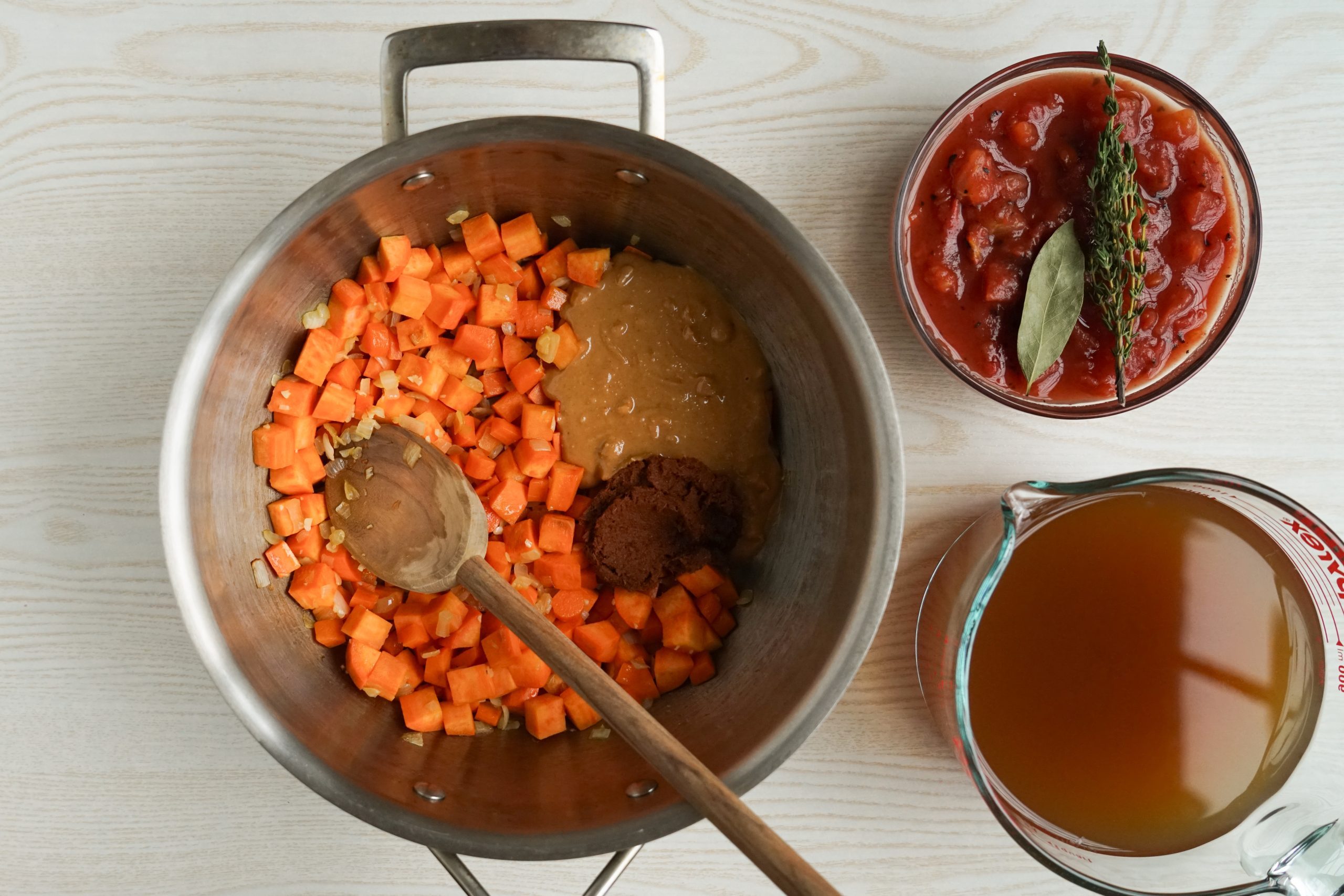 Adding broth, peanut butter, and other ingredients to peanut soup