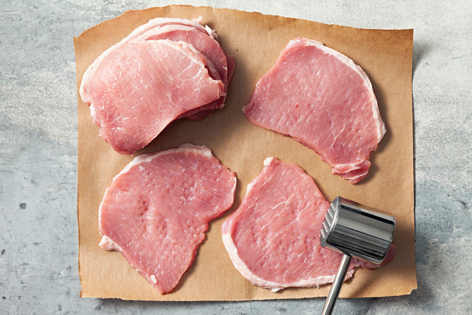 top view of pounding pork with meat mallet