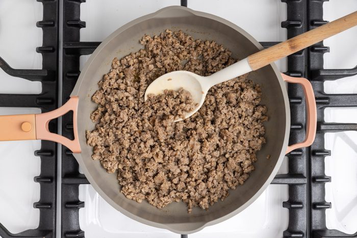 Pork sausage being cooked in skillet.