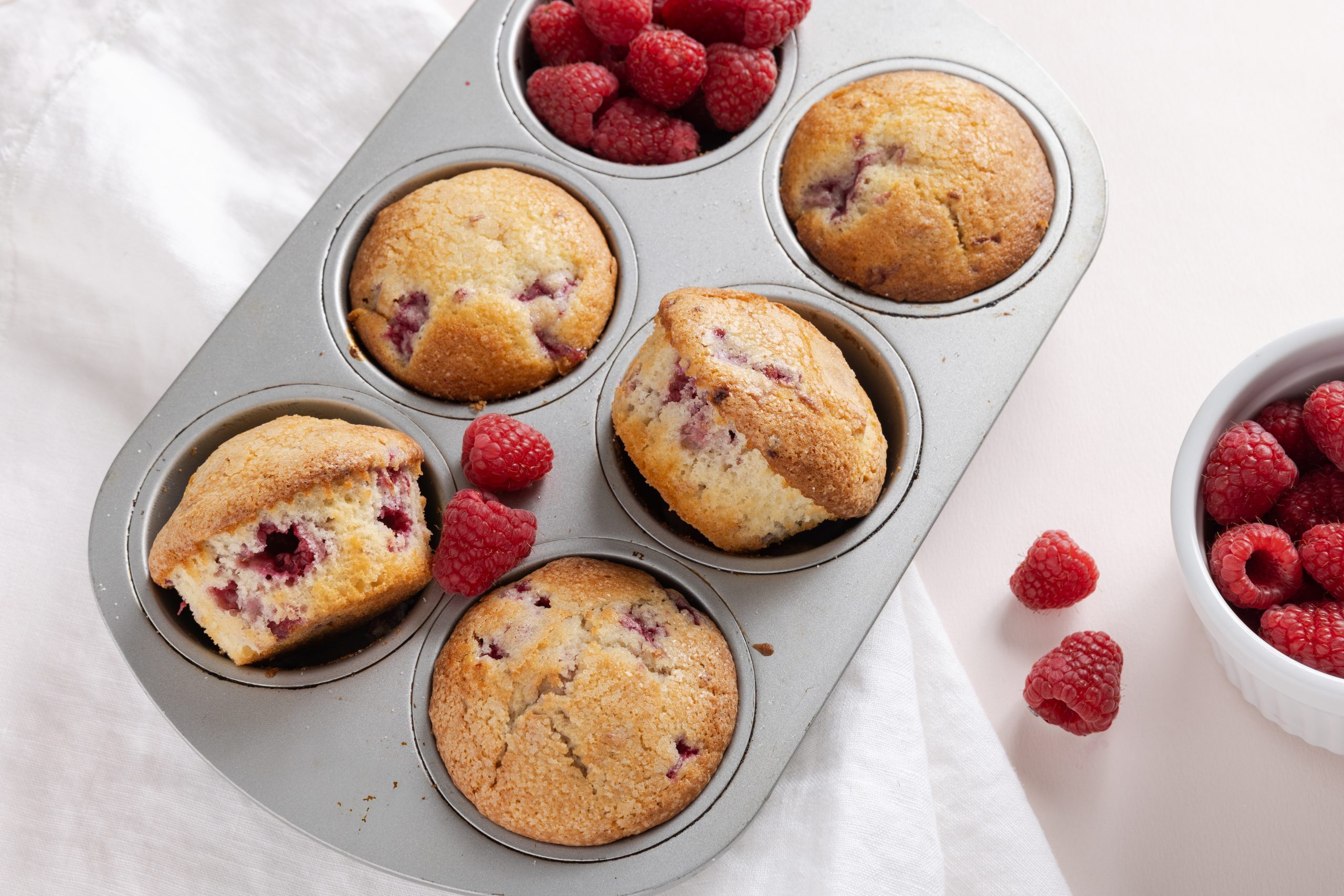 Muffins In Baking Tray With Fresh Raspberries.