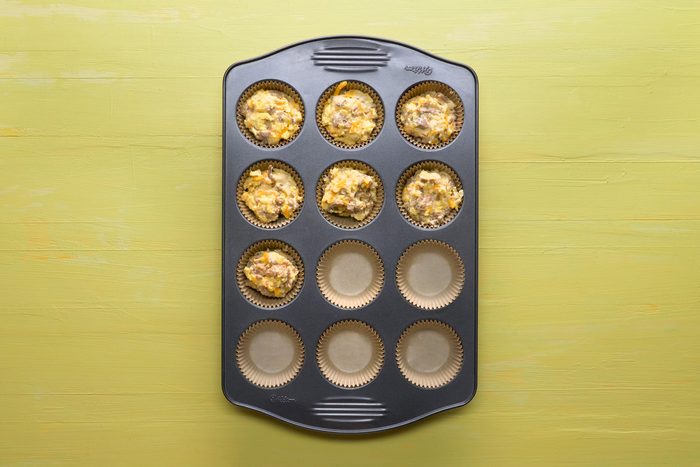 Top view shot of muffin cups three-fourths full with the muffin batter in baking tray