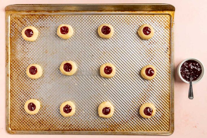 Taste of Home Shortbread Cookies with Jam recipe photo of the pressed dough balls with raspberry jam filling the holes.