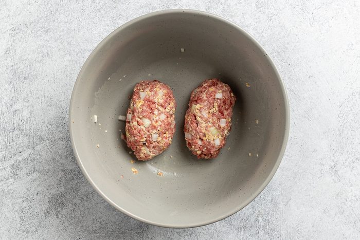 Taste of Home Skillet Meatloaf recipe photo of the ground beef, onion, oats, and salt combined and formed into loaves.