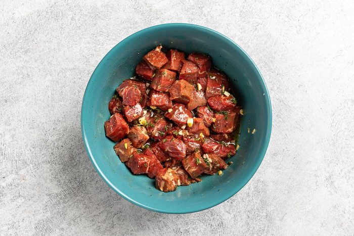 Taste of Home Steak and Potatoes recipe photo of the steak marinating in a large bowl.
