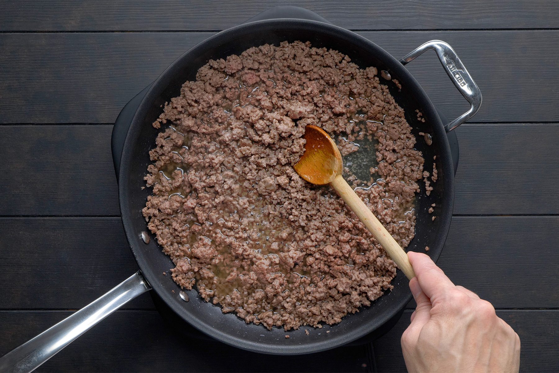overhead shot; black background; In a large saucepan, cooking beef;