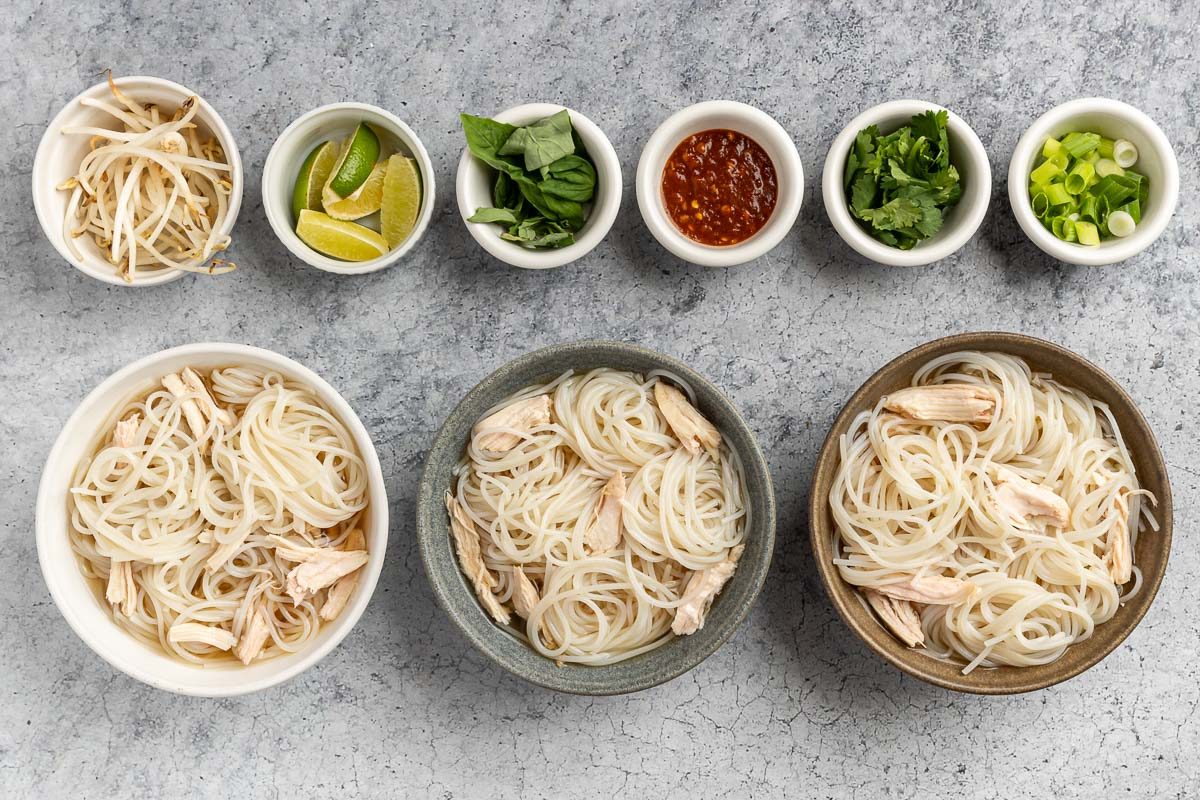 Taste of Home Thai Chicken Noodle Soup photo of the noodles, chicken, and broth in bowls with toppings on the side.