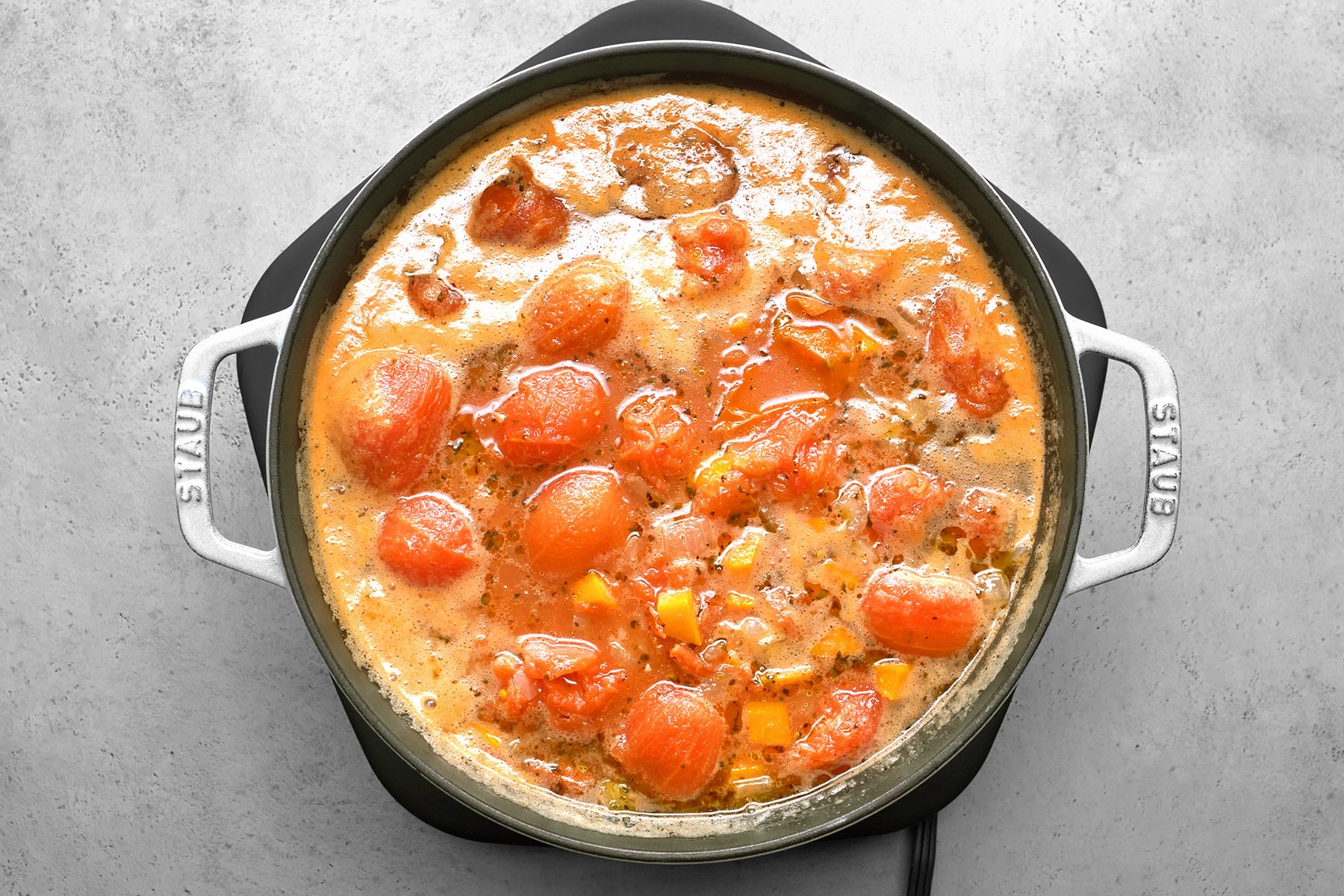 A pot of tomato soup is simmering.