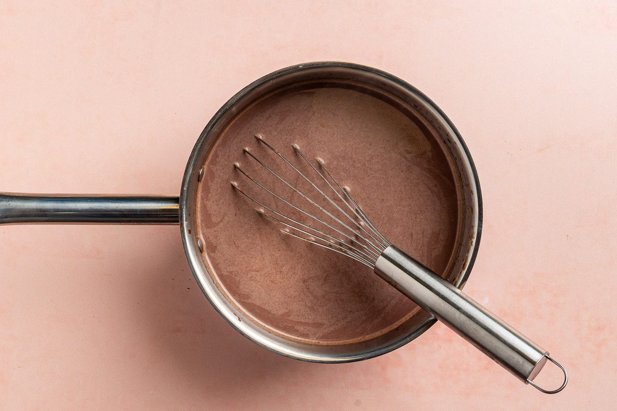 Taste of Home Vegan Hot Chocolate recipe photo of the sugar, dark baking cocoa, and the almond milk whisked and heated in a saucepan.