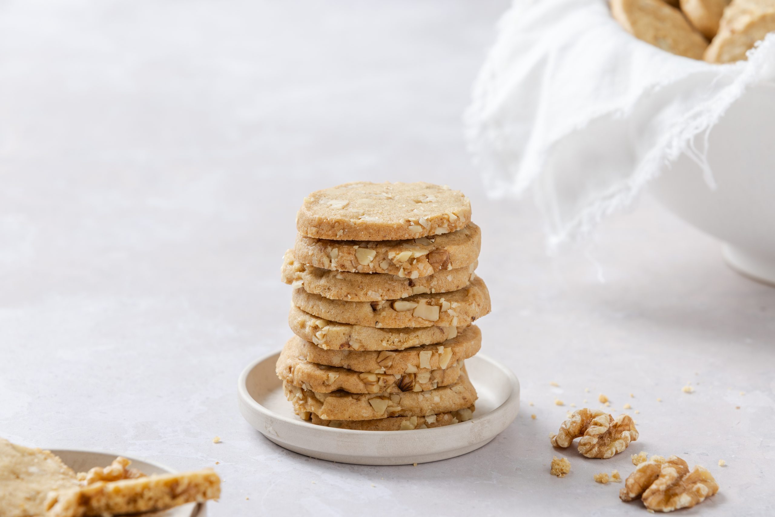 Walnut cookies piled up on small plate.