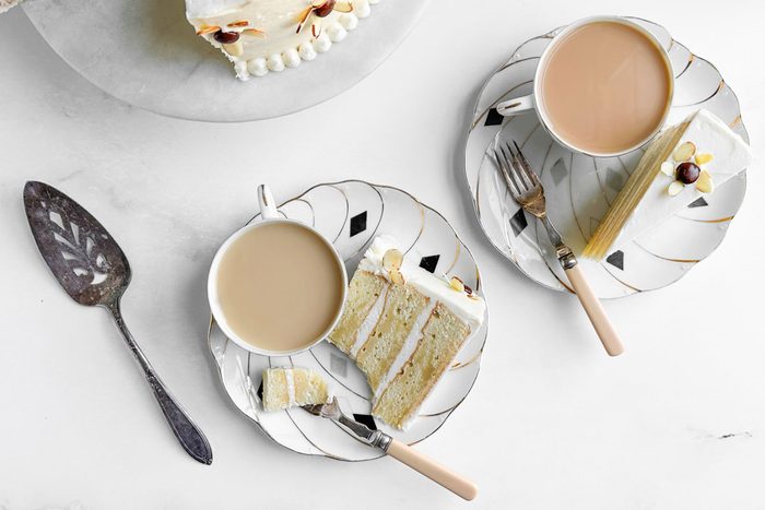 Taste of Home Amaretto Cake on cake plates and a cake stand with cups of tea