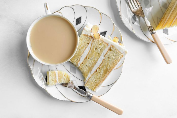Taste of Home Amaretto Cake on cake plates with cups of tea