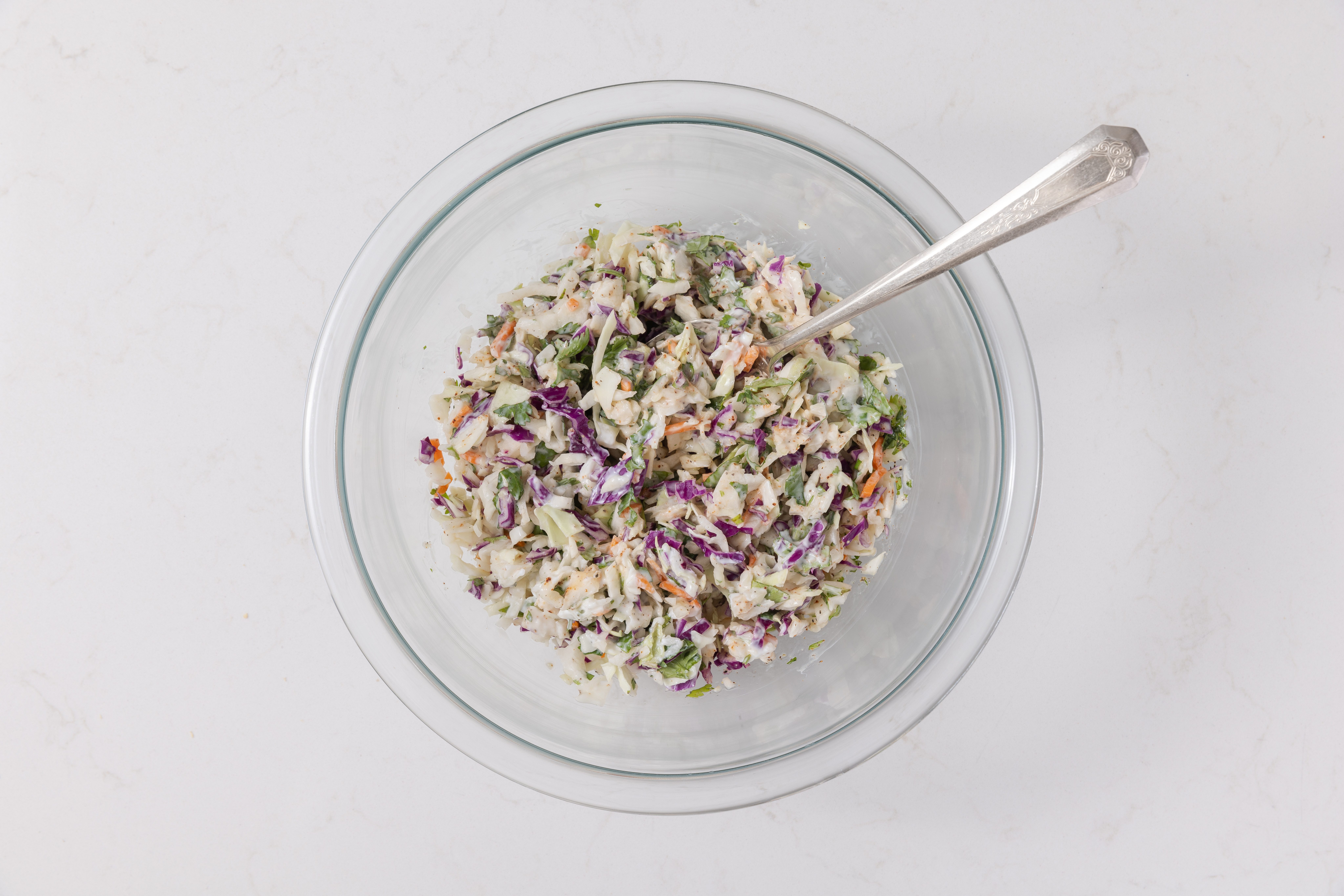 Ingredients for coleslaw mix mixed in a bowl.