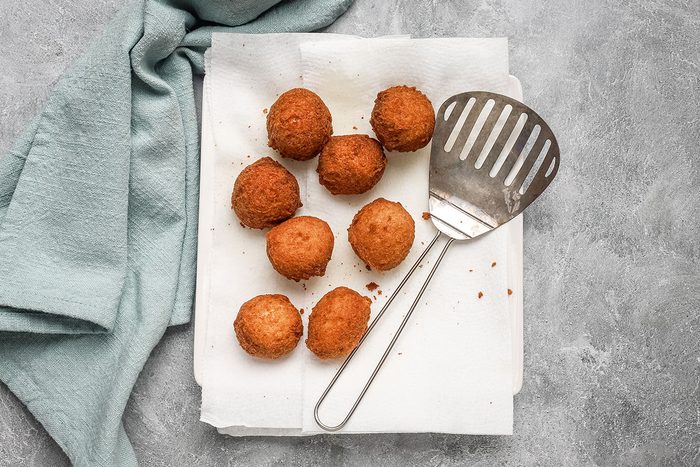 Fried banana beignets draining on paper towels.