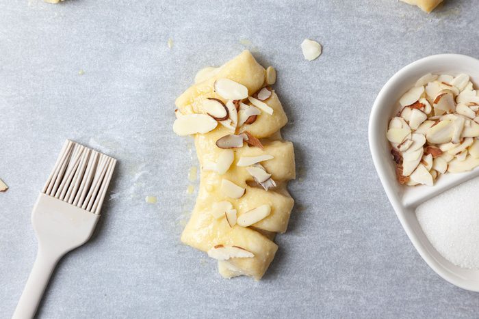 Step 6 of Taste of Home Bear Claw is to beat the water and remaining egg. Brush the mixture over the dough. Sprinkle with the sugar and almonds. Bake until golden brown, for about 15 minutes. Remove from the pans to wire racks to cool.